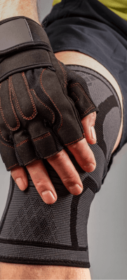 mão direita sobre o joelho direiro. Usando luvas de treino e joelheira. Joelho semi flexionado.