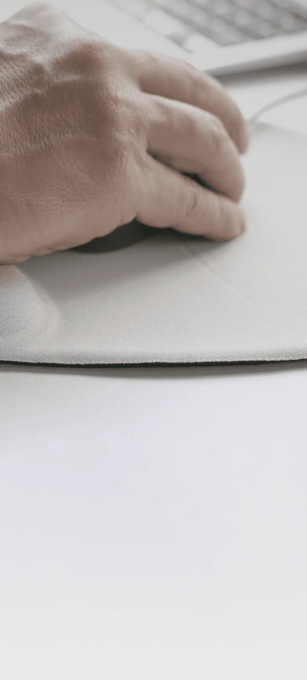 mão utilizando o mouse, imagem de parte do teclado de um laptop